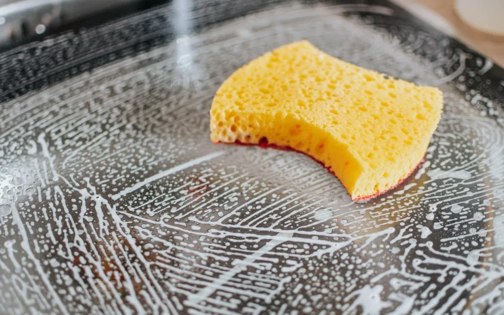 A sponge being used to clean a glass surface.